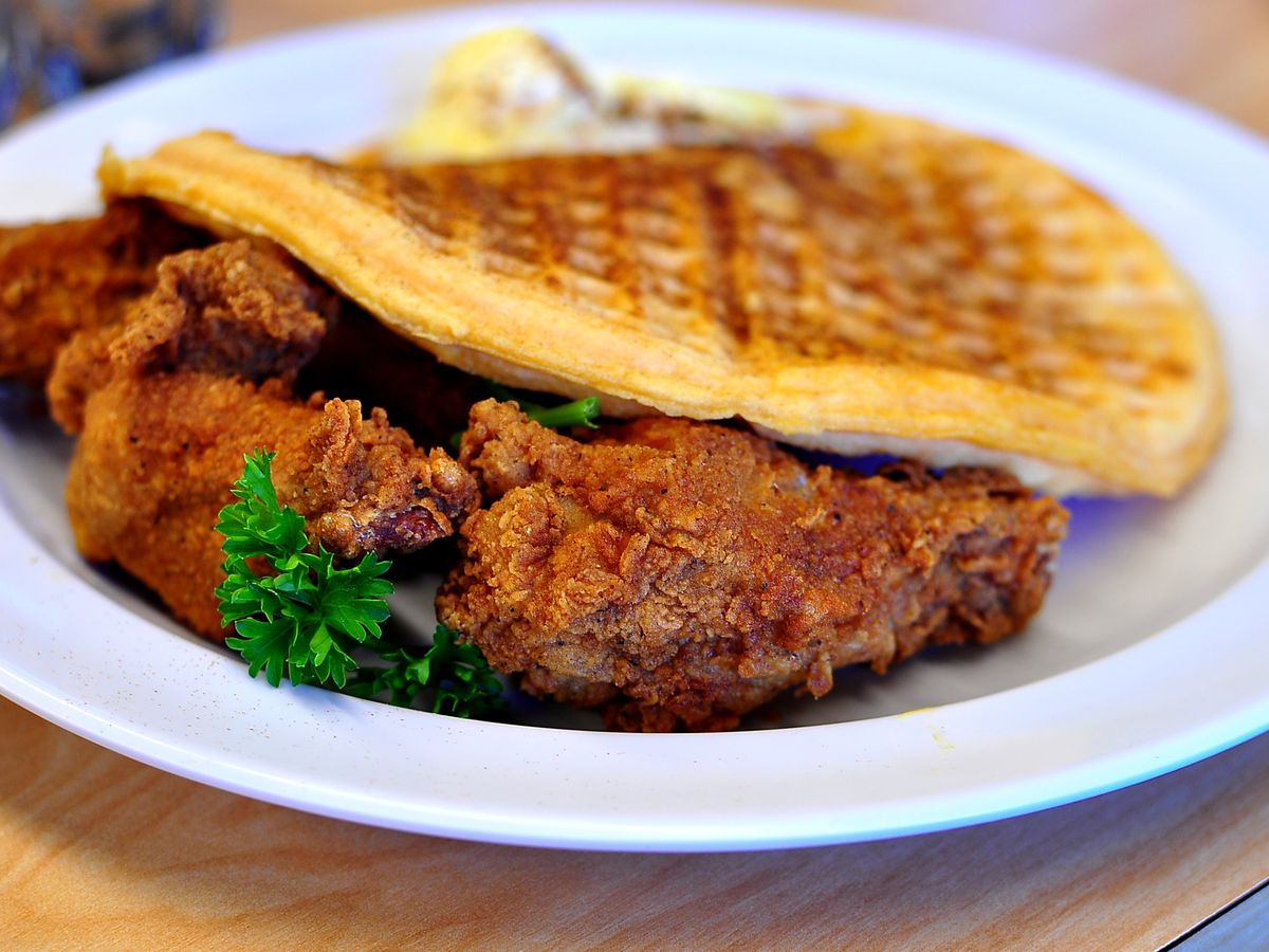 A plate of fried chicken tucked underneath a waffle from the Serving Spoon in Inglewood