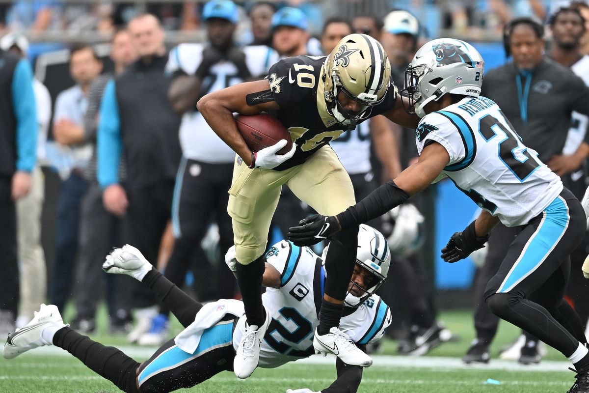 Jeremy Chinn #21 and CJ Henderson #24 of the Carolina Panthers attempt to tackle Tre’Quan Smith #10 of the New Orleans Saints during their game at Bank of America Stadium on September 25, 2022 in Charlotte, North Carolina.