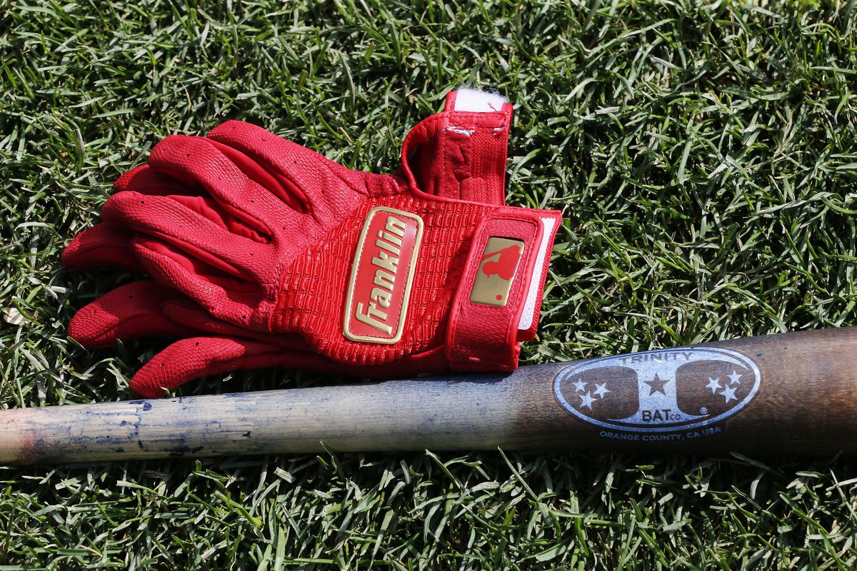 A bat and a set of Franklin baseball gloves belonging to Ben Zobrist #18 of the Chicago Cubs were sitting on the field non the first day of his return to the club following an absence of several months prior to a game between the Chicago Cubs and the Milwaukee Brewers at Wrigley Field on September 01, 2019.