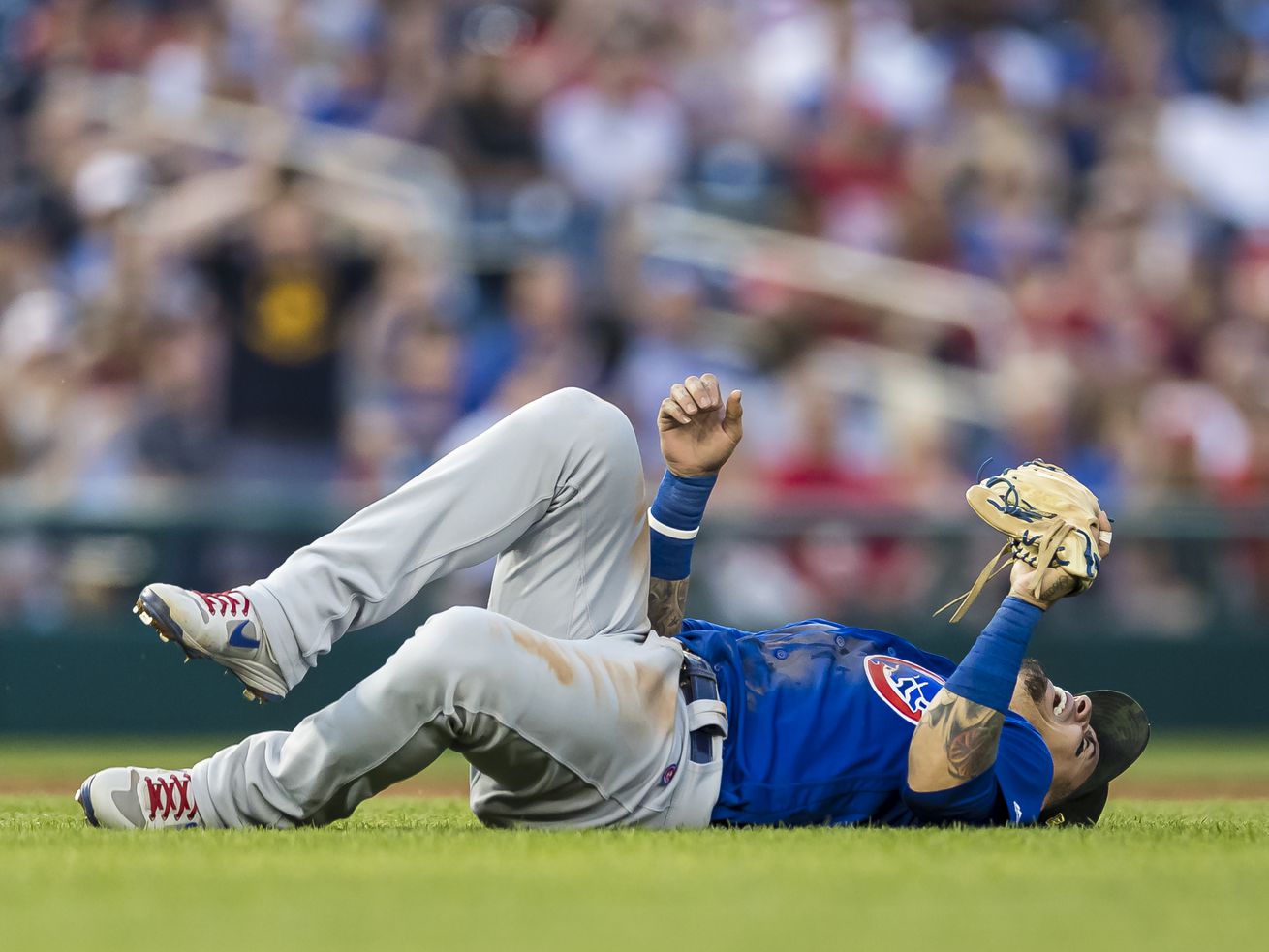Baez on the ground in pain after making a spectacular, charging play on a slow roller to short in Sunday’s third inning.