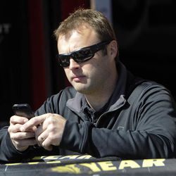 NASCAR driver Travis Kvapil uses a cell phone in the garage at Atlanta Motor Speedway Friday, Feb. 27, 2015, in Hampton, Ga. Kvapil's NASCAR Sprint Cup car was stolen early Friday, forcing him to withdraw from a race this weekend at Atlanta Motor Speedway.  
