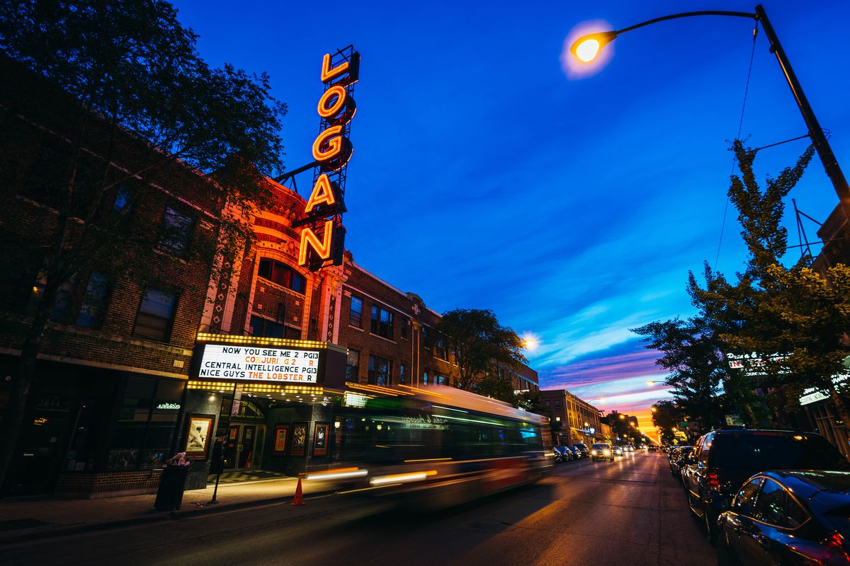 A red neon sign that reads ‘Logan’ for the Logan Theater glows at night in Chicago.