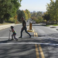 Jon Owen and his son Ben cross the street from their house on Thursday, Oct. 30, 2014, in Salt Lake City. Ben was diagnosed with autism spectrum disorder at age 2. Jon is president of the Utah Autism Coalition.