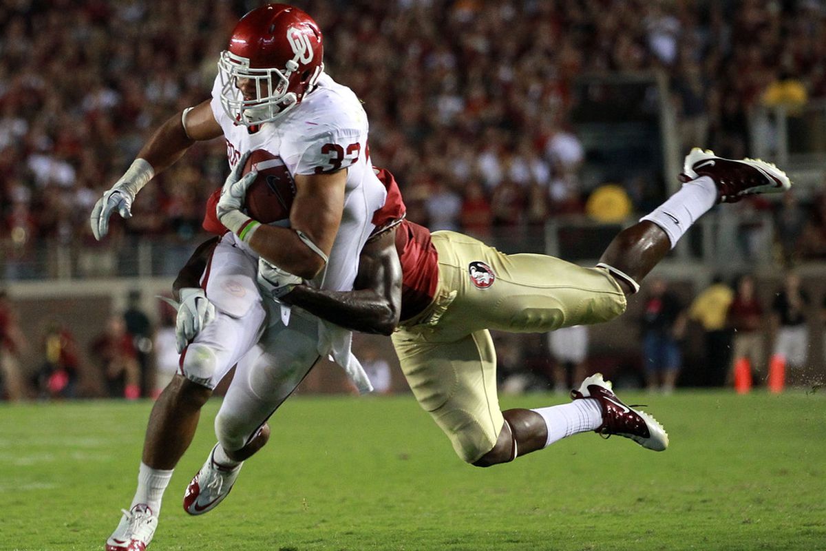 TALLAHASSEE, FL - SEPTEMBER 17: Trey Millard #33 of the Oklahoma Sooners is tackled by Nigel Bradham #13 of the Florida State Seminoles at Doak Campbell Stadium on September 17, 2011 in Tallahassee, Florida.  (Photo by Ronald Martinez/Getty Images)