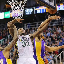 Utah Jazz forward Trevor Booker (33) is fouled as he is guarded by Los Angeles Lakers center Jordan Hill (27) and Los Angeles Lakers forward Wesley Johnson (11) as the Jazz and the Lakers play Wednesday, Feb. 25, 2015, at EnergySolutions Arena in Salt Lake City.