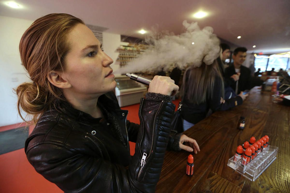Talia Eisenberg, co-founder of the Henley Vaporium, uses her vaping device in New York. Soon, the Food and Drug Administration will propose rules for e-cigarettes. The rules will have big implications for a fast-growing industry and its legions of custome