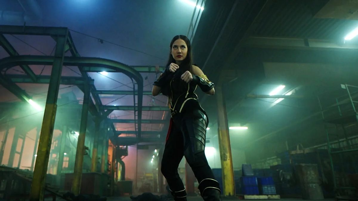 Sri Asih, a young woman in a superhero outfit, raises her fists up to fight in Sri Asih
