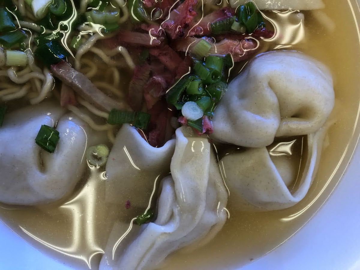 A bowl of saimin with noodles, dumplings, and meat
