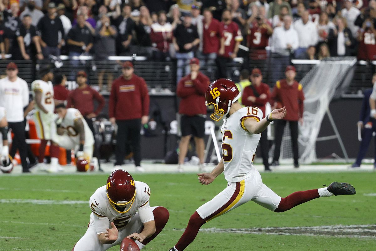 Punter Tress Way #5 of the Washington Football Team holds for kicker Brian Johnson #16 on a successful 48-yard field goal attempt against the Las Vegas Raiders with 37 seconds left in the fourth quarter of their game at Allegiant Stadium on December 5, 2021 in Las Vegas, Nevada.