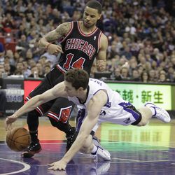 Sacramento Kings guard Jimmer Fredette, right, dives after the ball against Chicago Bulls guard D.J. Augustin, during the fourth quarter of an NBA basketball game in Sacramento, Calif., Monday, Feb. 3, 2014. The Kings won 99-70. (AP Photo/Rich Pedroncelli)