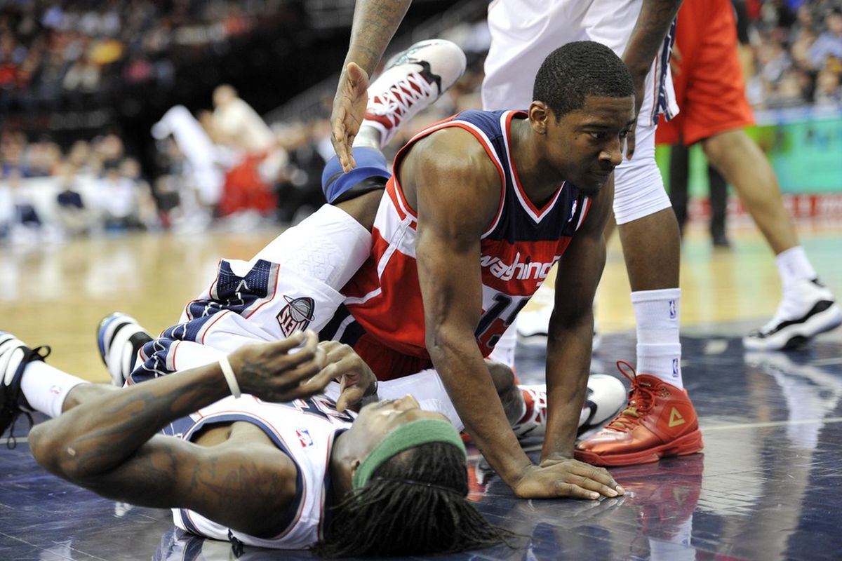Apr 6, 2012; Newark, NJ, USA;  Washington Wizards guard Jordan Crawford (15) falls over New Jersey Nets forward Shelden Williams (33) during the first half at  the Prudential Center.  Mandatory Credit: Joe Camporeale-US PRESSWIRE