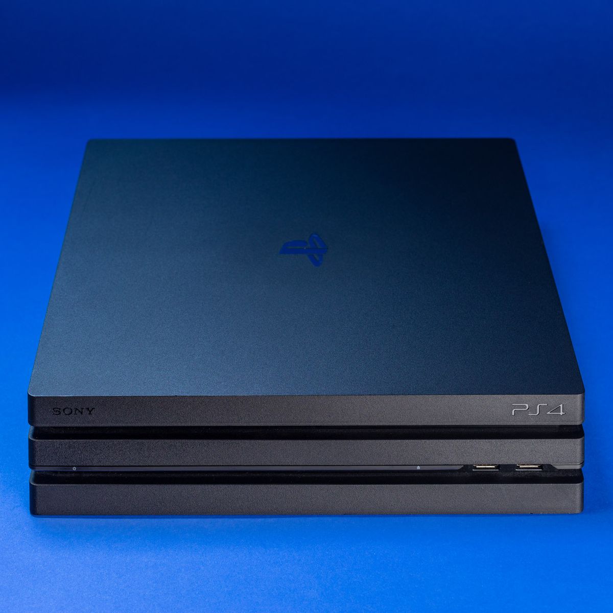 PS4 Pro, front view on blue background