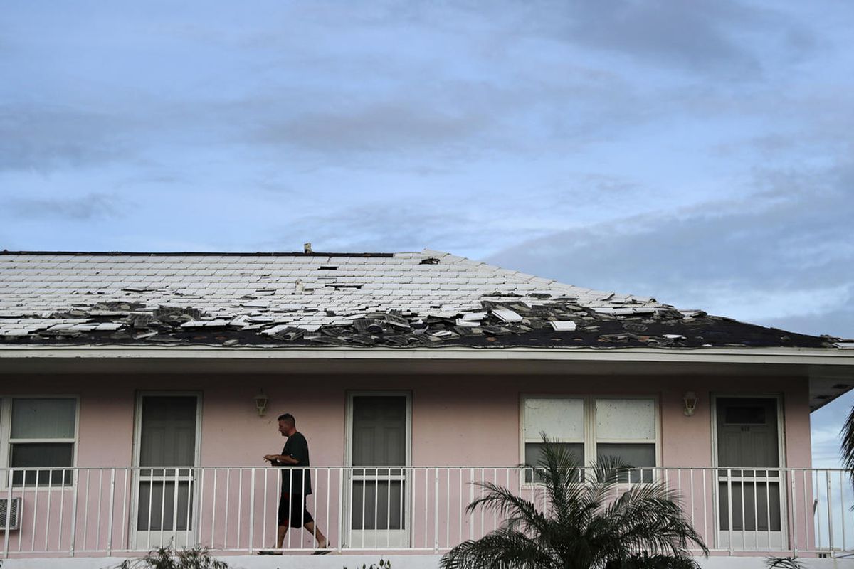 Tony Loduca walks back to his apartment past a roof whose tiles where torn off from Hurricane Irma in Marco Island, Fla., Monday, Sept. 11, 2017. (AP Photo/David Goldman)
