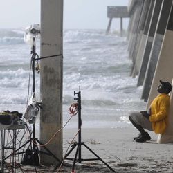Paul Jackson with CNN's storm coverage team waits to do a live shot under Johnnie Mercer's Pier in Wrightsville Beach, N.C., Friday, June 7, 2013. Tropical Storm Andrea is bringing rain and wind to Carolinas, causing thousands to lose power and streams to swell.  The storm was racing through South Carolina early Friday and was expected to move into eastern North Carolina by midday.  