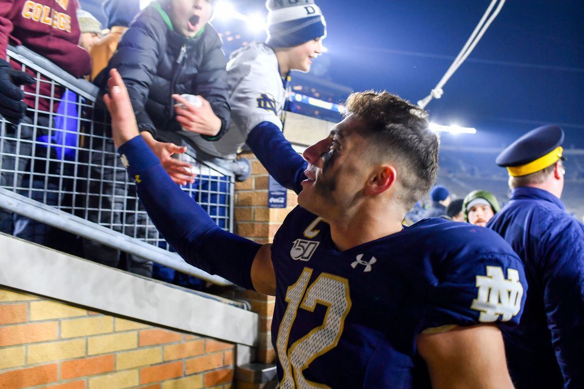 Notre Dame Fighting Irish quarterback Ian Book greets fans as he leaves the field following the 40-7 win over the Boston College Eagles at Notre Dame Stadium.