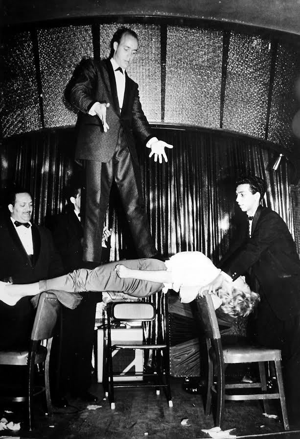 Hypnosis and levitation were among Marshall Brodien’s signature acts during his early years. Here, he’s standing on a woman who is hypnotized and lying on the backs of two chairs. | Marshall Brodien collection