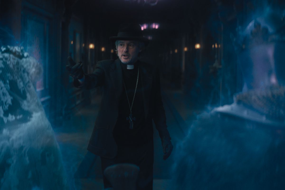 Owen Wilson as Father Kent, confronting two ghosts in the hallway in 2023’s Haunted Mansion