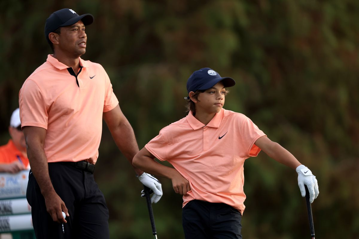 Tiger Woods and Charlie Woods wait to play on the 17th hole during the first round of the PNC Championship at the Ritz Carlton Golf Club Grande Lakes on December 18, 2021 in Orlando, Florida.