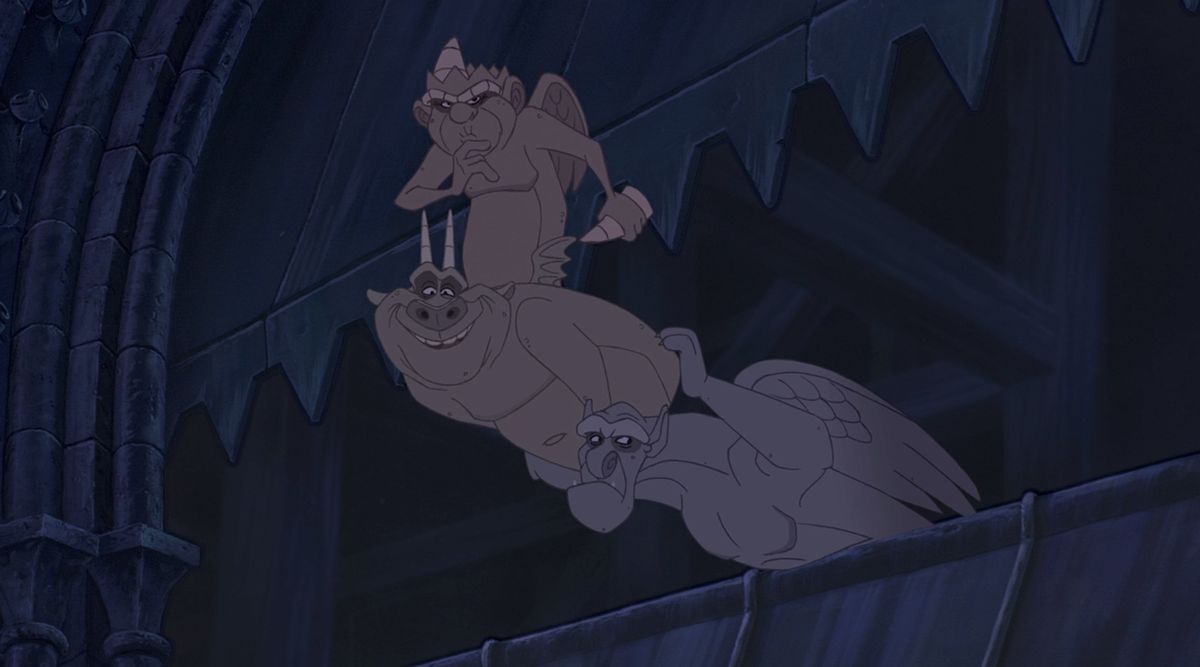 The three gargoyles from Disney’s 1996 animated movie The Hunchback of Notre Dame lean waaaaay out over a parapet, stacked on top of each other and making goofy faces