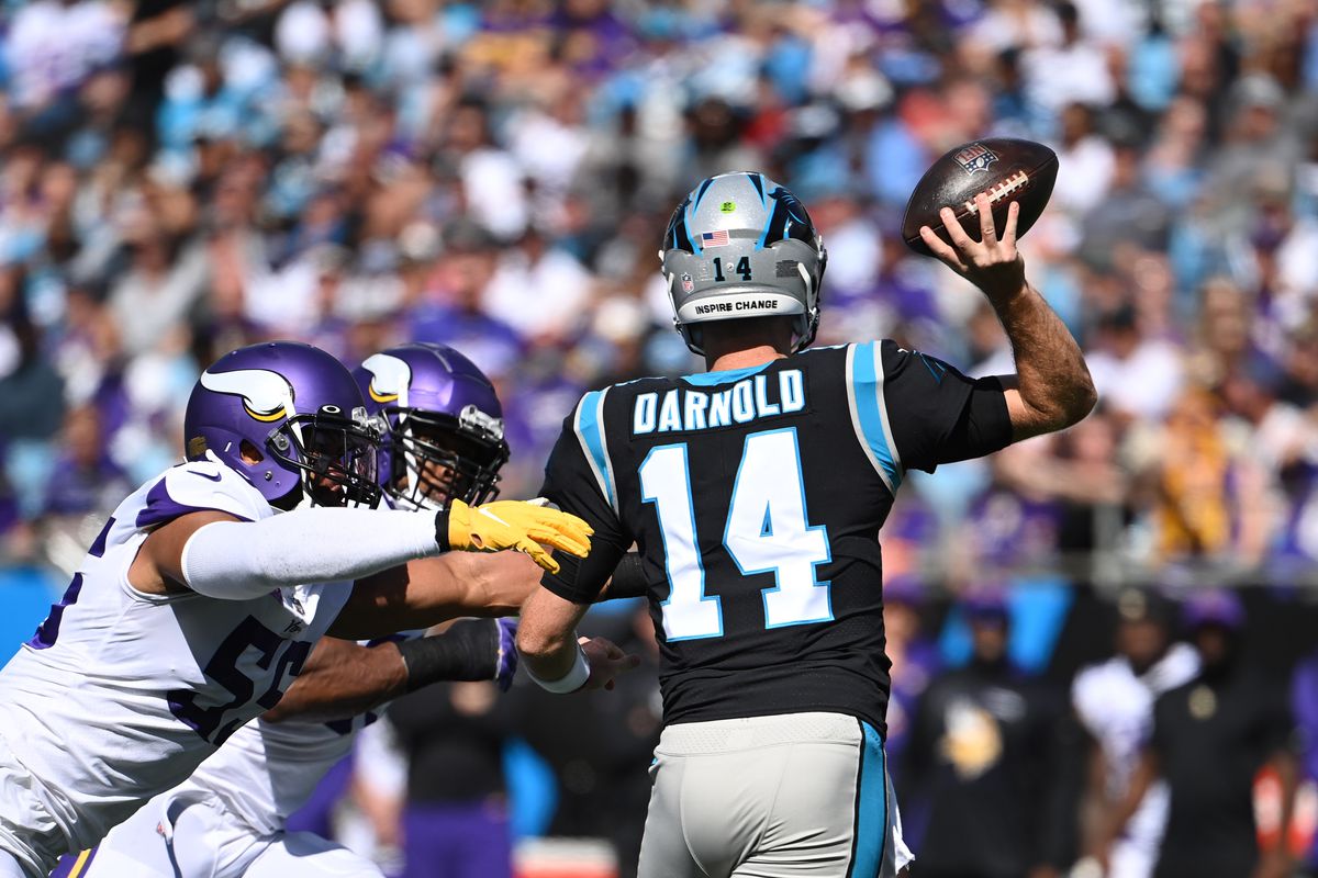 Carolina Panthers quarterback Sam Darnold (14) looks to pass as Minnesota Vikings outside linebacker Anthony Barr (55) and defensive end Danielle Hunter (99) defend in the second quarter at Bank of America Stadium.