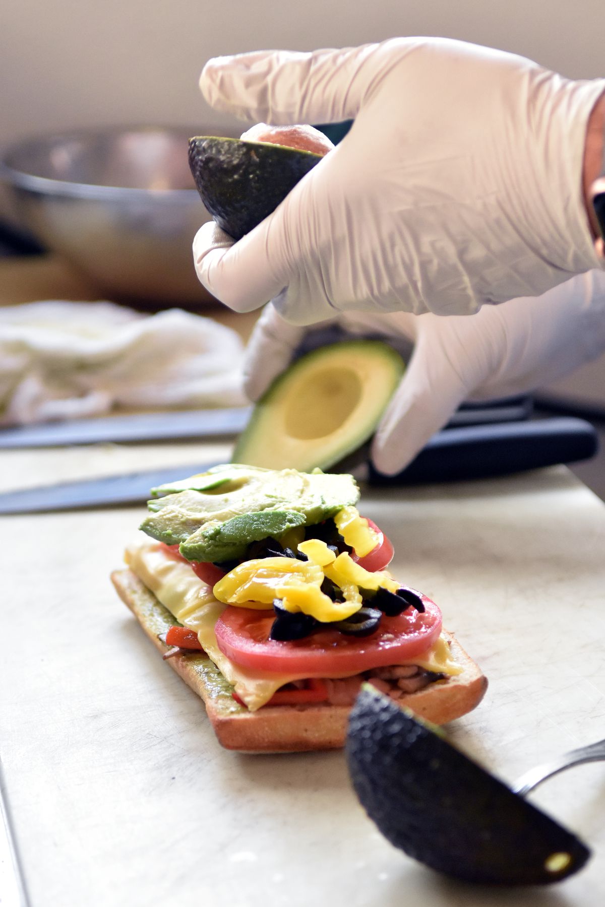 Cutting avocado over a sandwich. 