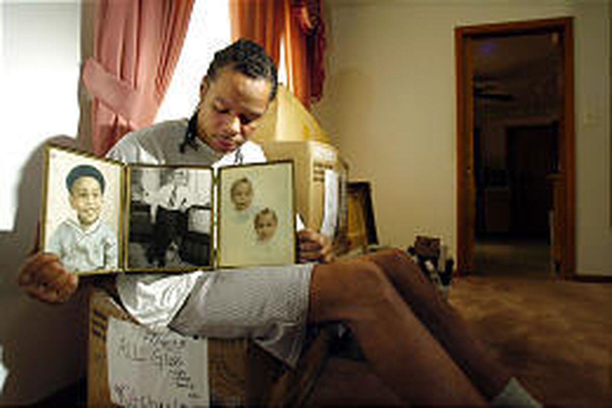 Abriel Thomas, a cousin of Emmett Till, holds a triptych showing childhood photos of Till in his home in Chicago Monday.