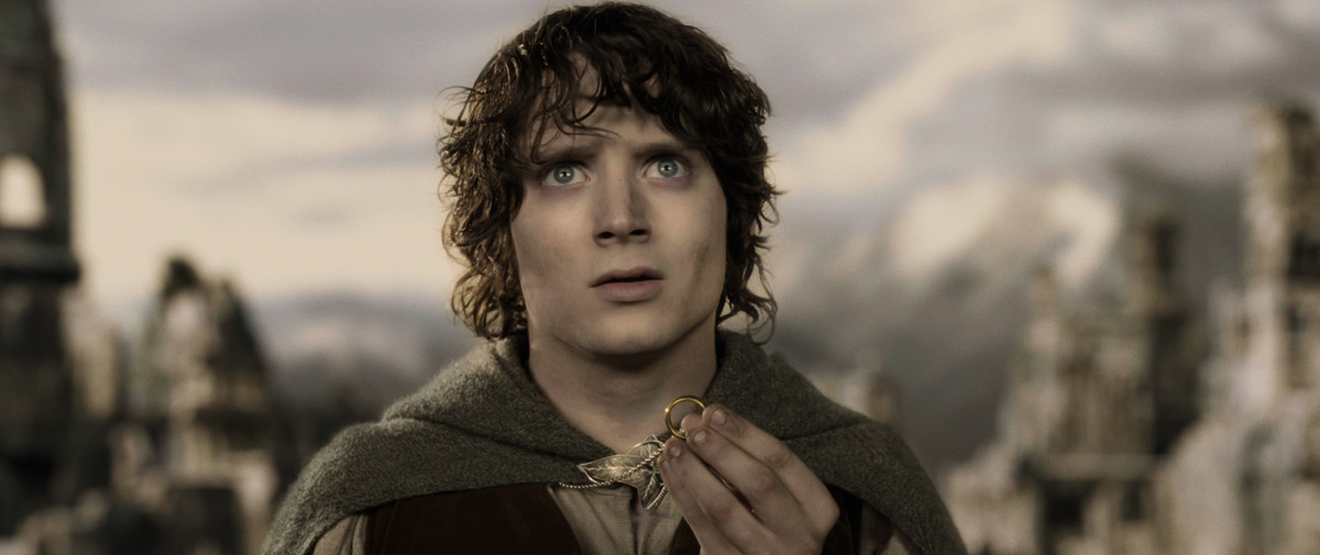 a weathered Frodo holding the ring and looking upward in The Lord of the Rings: The Two Towers