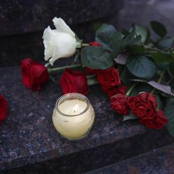 Flowers and candles are placed at the well-known military choir's building in Moscow, Russia, Sunday, Dec. 25, 2016, after a plane carrying 64 members of the Alexandrov Ensemble, crashed into the Black Sea minutes after taking off from the resort city of Sochi. The Russian plane was headed for an air base in Syria with 92 people aboard, Russia's Defense Ministry said. 