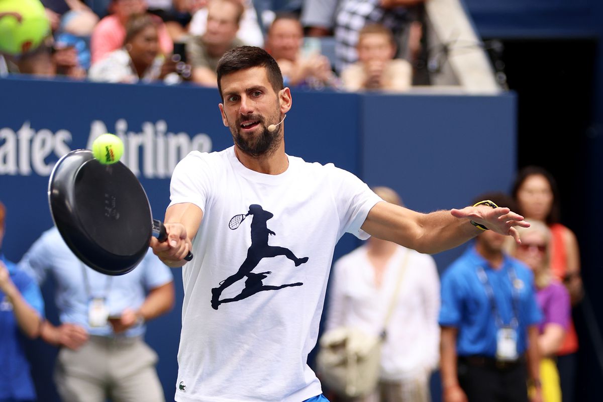 Novak Djokovic of Serbia plays tennis with a frying pa as a racket during Arthur Ashe Kids’ Day at USTA Billie Jean King National Tennis Center on August 26, 2023 in New York City.