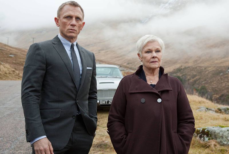 Bond and M stand in front of a fancy car in misty Scotland in Skyfall
