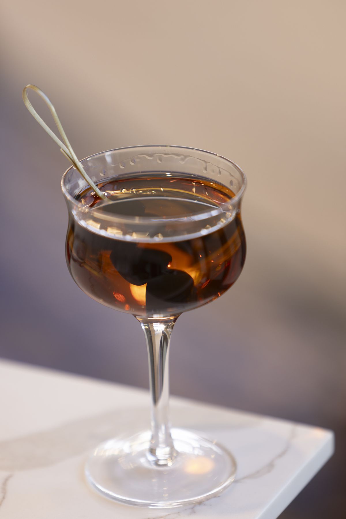 A brown cocktail in a high stem glass at Alice B. restaurant in Palm Springs, California.