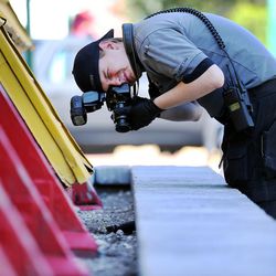 A crime scene photographer takes photos of a handgun that was dumped at 800 West and 200 North in Salt Lake City following a shooting at 757 W. 200 North in Salt Lake City on Tuesday, Aug. 15, 2017.