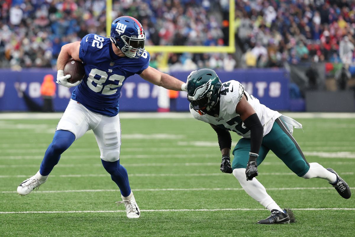 Daniel Bellinger #82 of the New York Giants attempts to avoid a tackle by K’Von Wallace #42 of the Philadelphia Eagles during the second half at MetLife Stadium on December 11, 2022 in East Rutherford, New Jersey.
