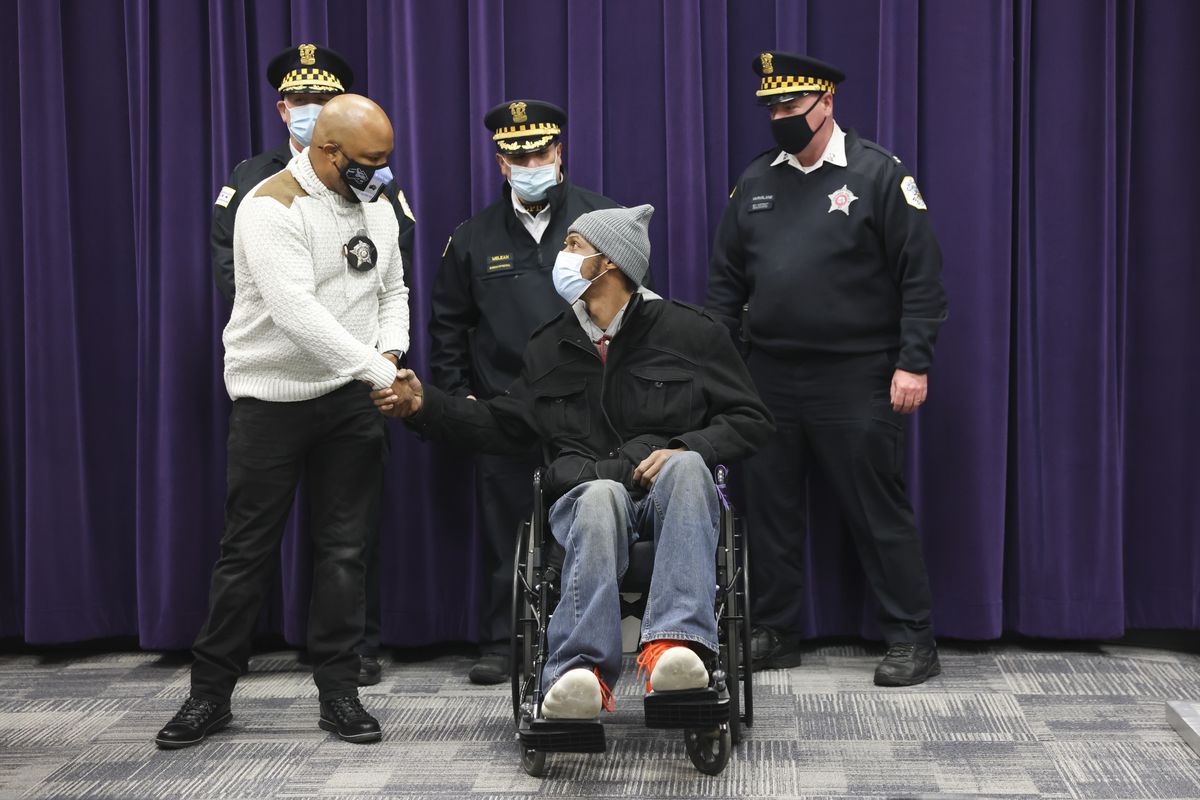 Officer Adrian McCoy, left, greets Joseph Ortiz whom he saved from an apartment fire during press conference at the Chicago Police Headquarters at 3510 S Michigan Ave in Bronzeville, Thursday, Dec. 23, 2021.