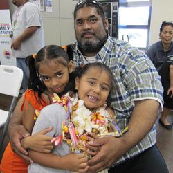 Five-year-old Leomomi Dew, front center, poses for a portrait with her sister Leolani Dew and her father, Leo Dew, after a graduation ceremony for Ka Paalana Traveling Preschool in Honolulu on Thursday, June 27, 2013. 