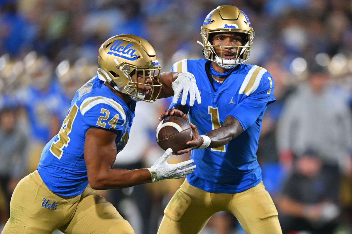 UCLA Bruins quarterback Dorian Thompson-Robinson hands off to running back Zach Charbonnet in the first half against the Washington Huskies at the Rose Bowl.