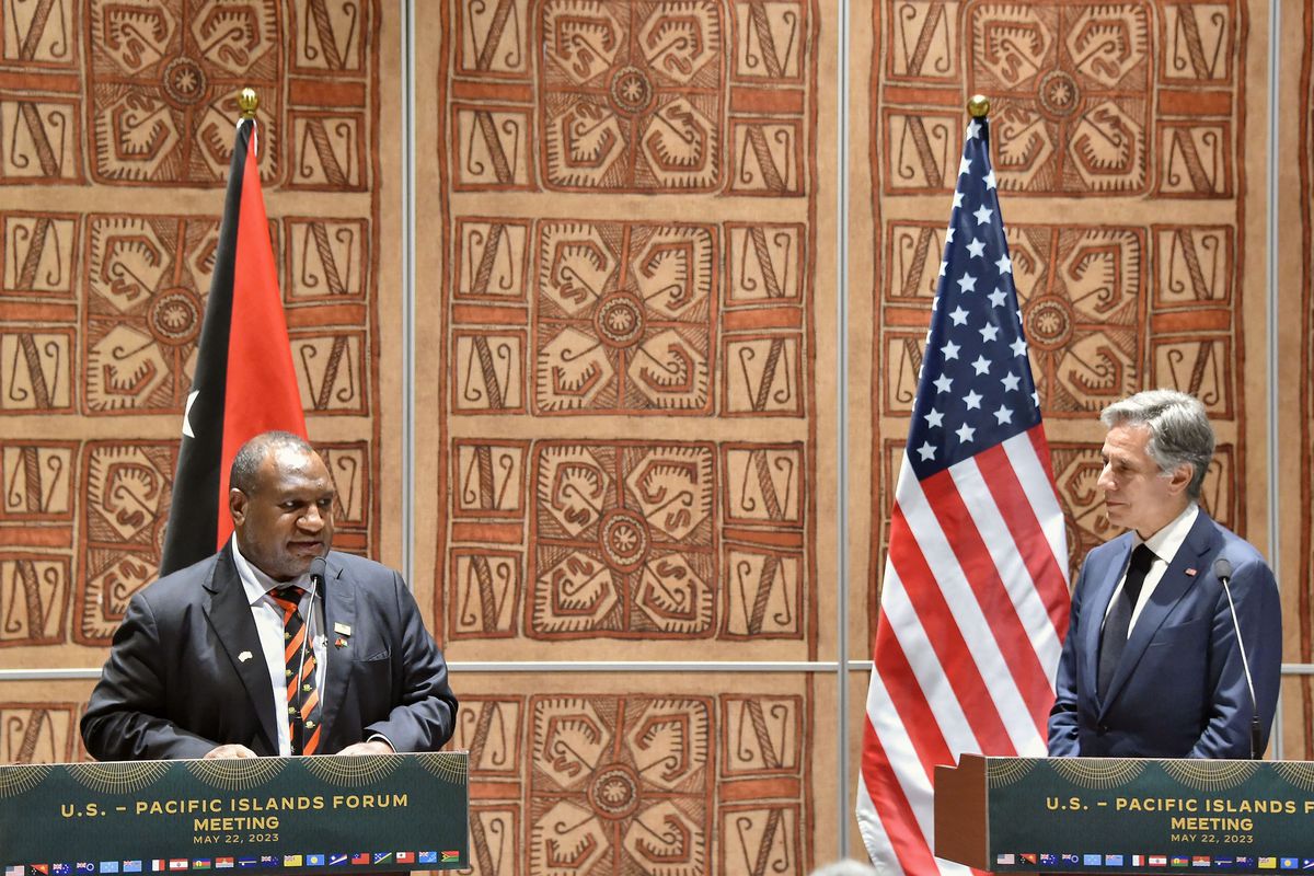 Prime Minister Marape and Secretary of State Blinken stand behind green podiums flanked by Papa New Guinea and United States flags.