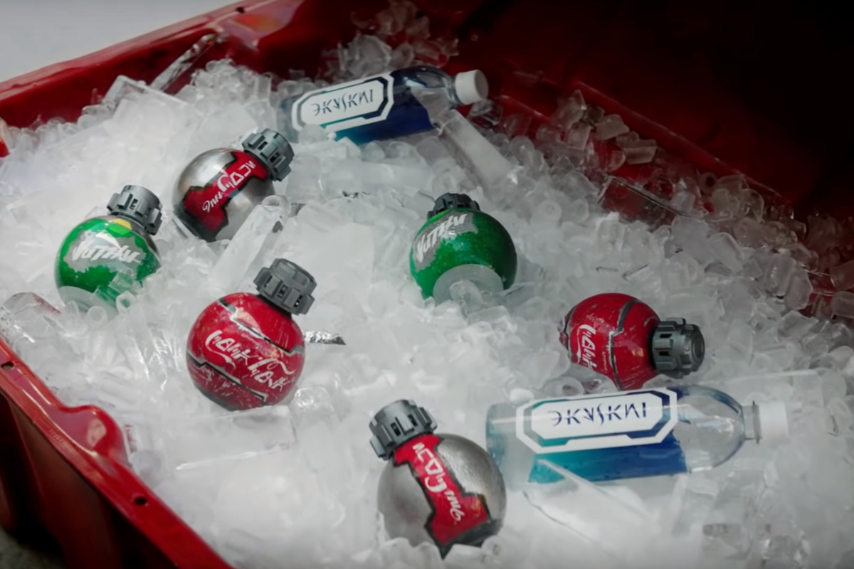 Spherical, grenade-shaped soft drink bottles lying on top of ice in a cooler.