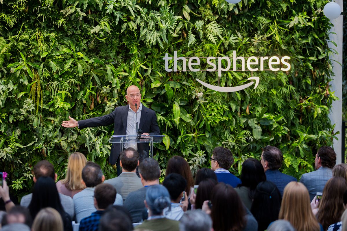 Then-CEO of Amazon, Jeff Bezos, speaks to an audience in front of a wall of greenery inside the Amazon Spheres building in Seattle.