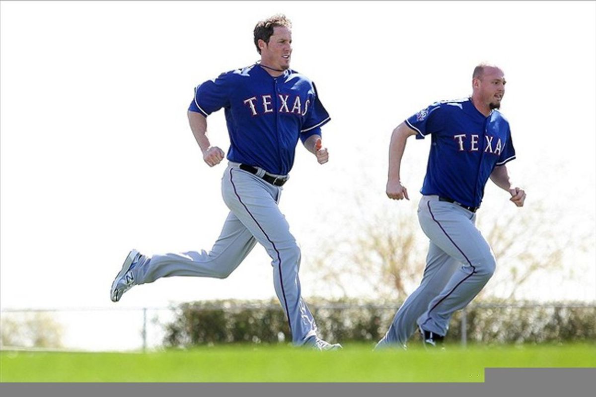 Feb 23, 2012; Surprise, AZ, USA; Texas Rangers pitcher Joe Nathan (center) and pitcher Matt Harrison run sprints during a workout at Surprise Stadium.  Mandatory Credit: Jake Roth-US PRESSWIRE