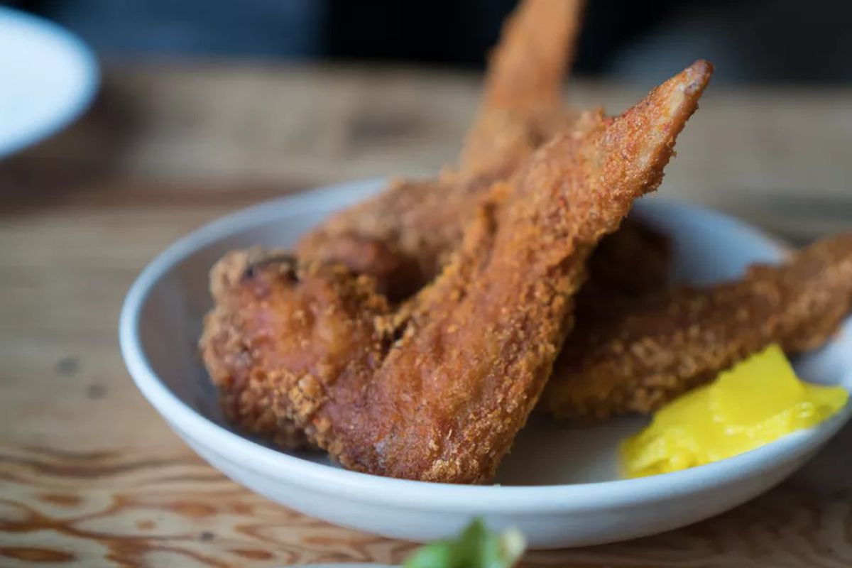 Two large, dry-fried wings at Han Oak with yellow daikon bread-and-butter pickles