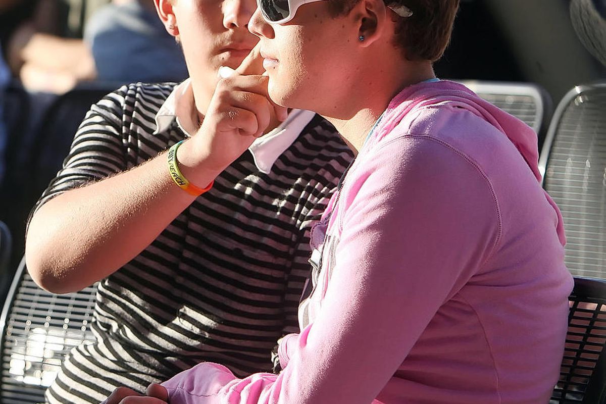 Bryton Catlett, left, wipes a tear off the cheek of his partner Patrick McAtee as they listen to the speakers. Members of the community stand Tuesday, May 1, 2012 in solidarity with (lesbian, gay, bisexual and transgender) LGBT youth, at the Ogden Amphith