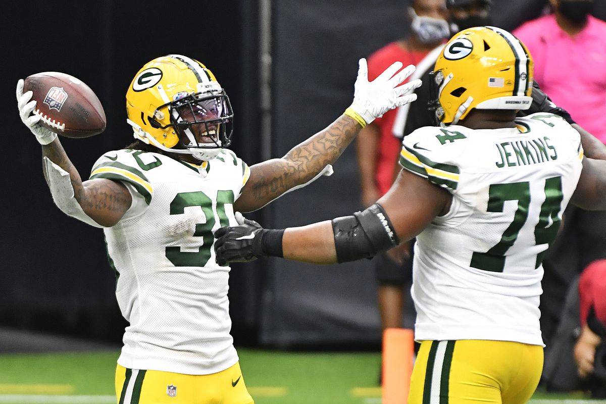 Jamaal Williams #30 of the Green Bay Packers celebrates with Elgton Jenkins #74 after rushing for a touchdown against the Houston Texans during the fourth quarter at NRG Stadium on October 25, 2020 in Houston, Texas.