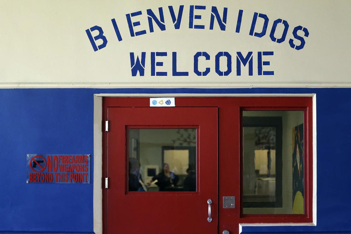 In this July 31, 2014 file photo, a Spanish and English welcome sign is seen above a door in a secured entrance area at the Karnes County Residential Center in Karnes City, Texas. The Department of Homeland Security released a report Friday, Feb. 6, 2015 