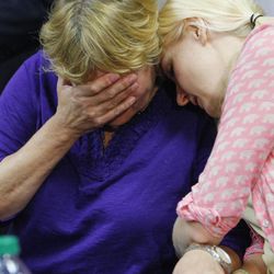Tara Evans covers her face as her emotions rise, and her daughter Karen comforts her during a press conference at Ogden's McKay-Dee Hospital Center as they talk about the condition of Tara's husband, James Evans, Monday, June 17, 2013. Police say James Evans was shot in the head by Charles Richard Jennings Jr. while attending Mass at St. James Catholic Church in Ogden.