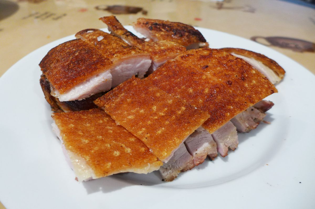 Slabs of baby pig with deep brown crunchy skin lay neatly stacked on the plate...