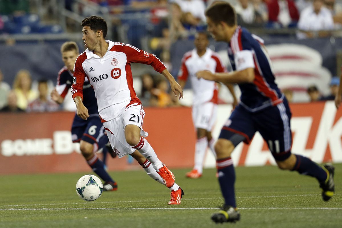 Toronto's Jonathan Osorio strides away from another Rookie of the Year candidate, New England's Scott Caldwell (6)