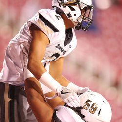 Desert Hills' Nephi Sewell (2) celebrates his touchdown with Penei Sewell (58) against Stansbury during the 3AA semifinal high school football game in Salt Lake City on Thursday, Nov. 10, 2016. Desert Hills won 49-14.