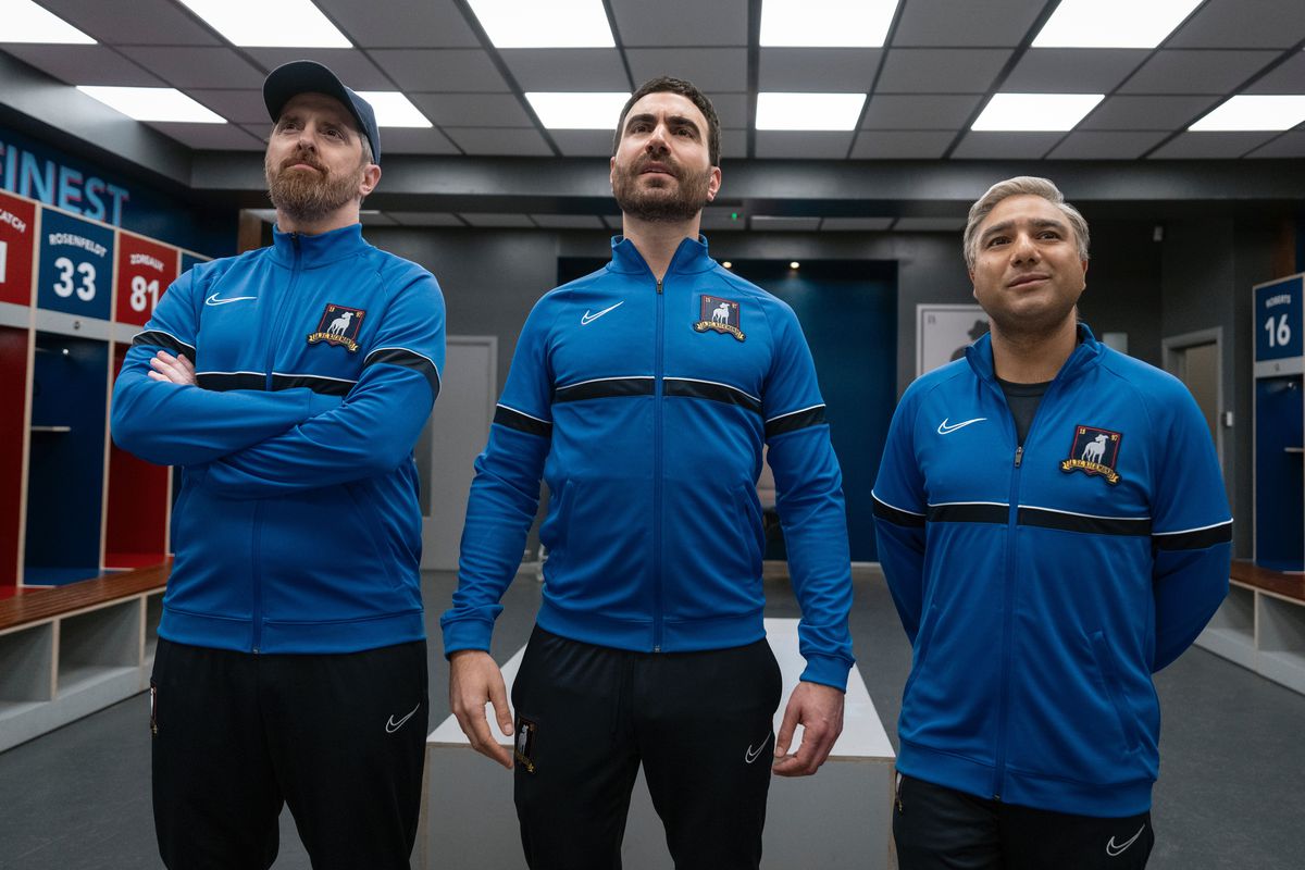 Beard, Roy, and Nate stand in the Richmond locker room in their new coaching uniforms 