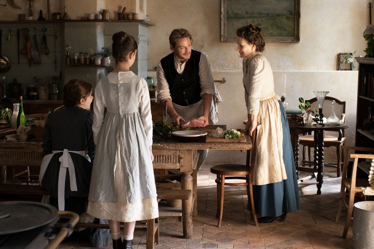 In a scene from The Taste of Things, chef Dodin speaks with Eugenie and two kitchen helpers.